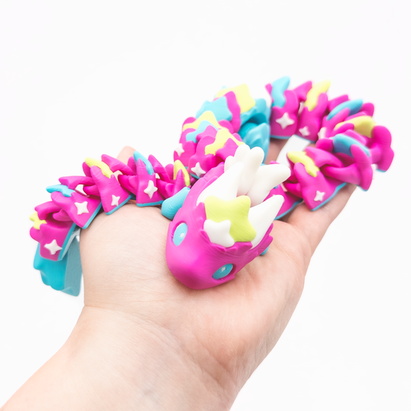 3D printed articulating Atria dragon held in palm of hand