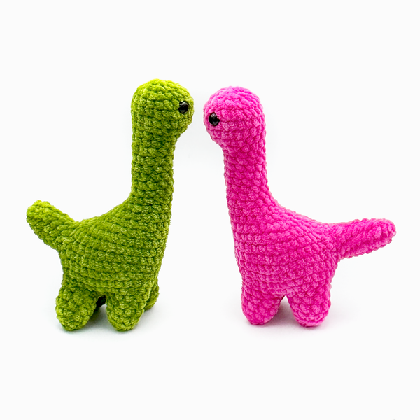 Two crochet amigurumi brontosaurus plushie in goblin green and hot pink