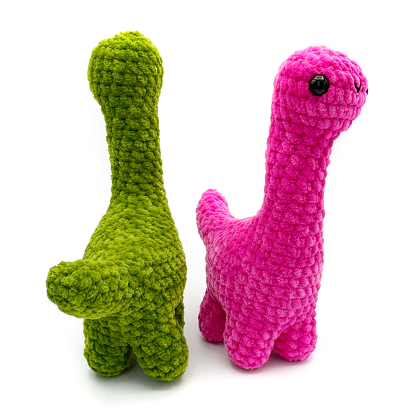 Two crochet amigurumi brontosaurus plushie in goblin green showing tail and hot facing forward