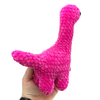 Crochet amigurumi brontosaurus plushie in hot pink held in hand showing tail