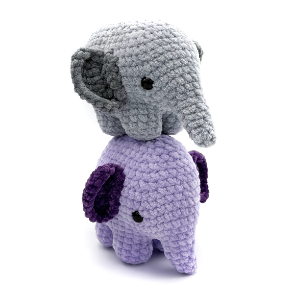 2 Crochet Amigurumi Elephants standing on top of each, bottom elephant is purple, top is gray