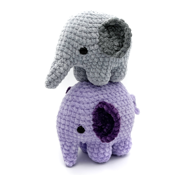 2 Crochet Amigurumi Elephants standing on top of each, bottom elephant is purple, top is gray