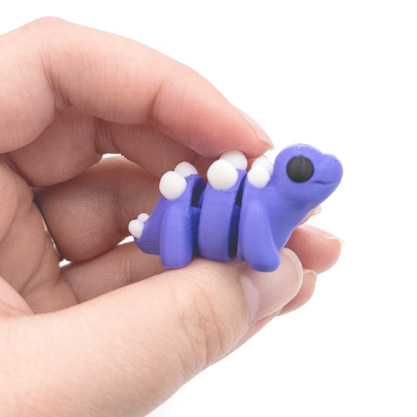 3D printed mini stegosaurus fidget creature held in hand