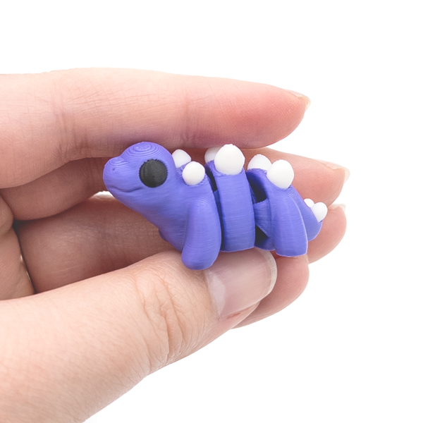 3D printed mini stegosaurus fidget creature held in and
