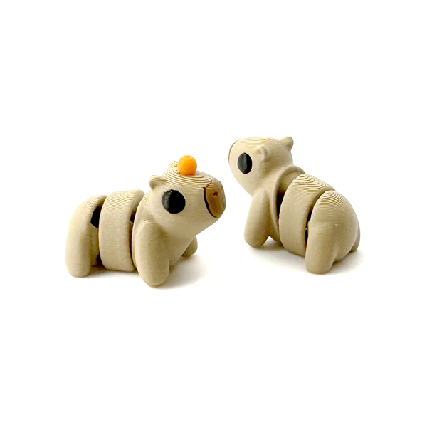 Two 3D Printed Mini Capybara fidgets, one with an orange on its head one without.