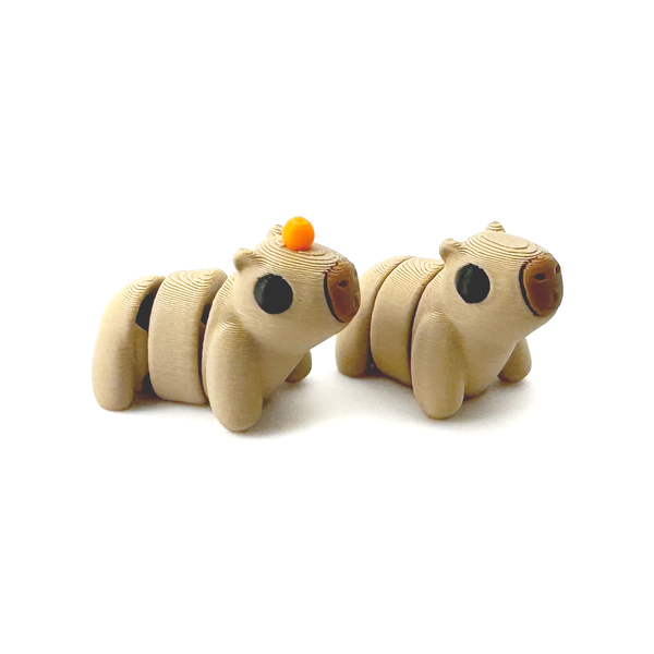 Two 3D Printed Mini Capybara fidgets, one with an orange on its head one without.