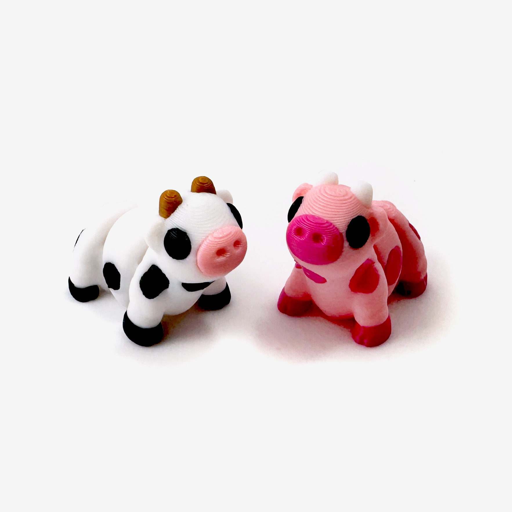 Two 3D printed mini cow fidgets