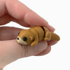 3D printed otter mini fidget creature laying on its tummy held in hand