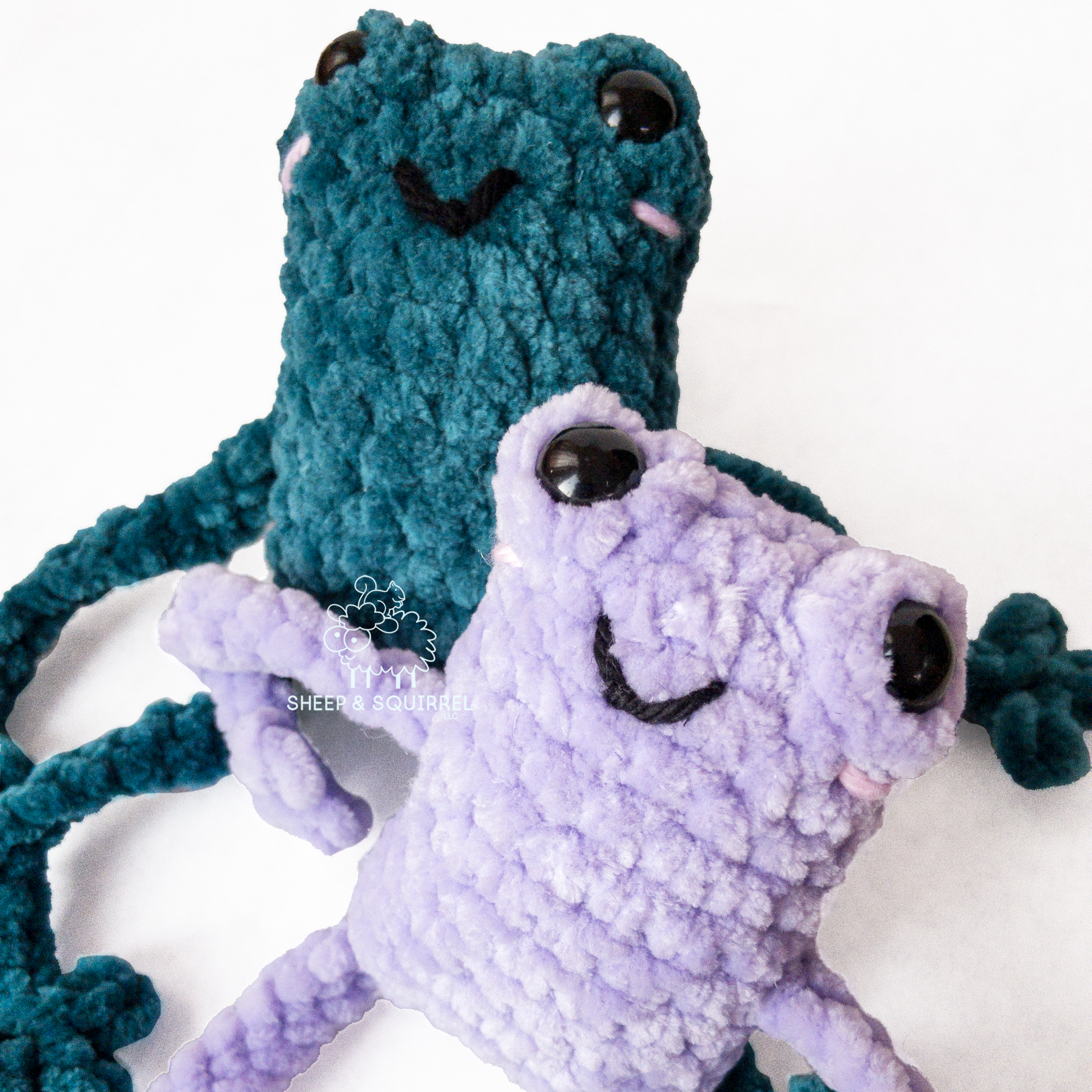 Two crochet amigurumi leggy frogs sitting