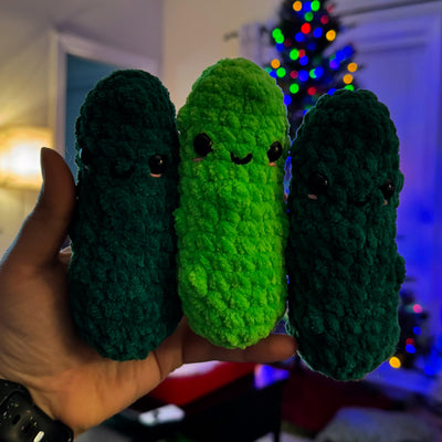 Three pickle amigurumi being held