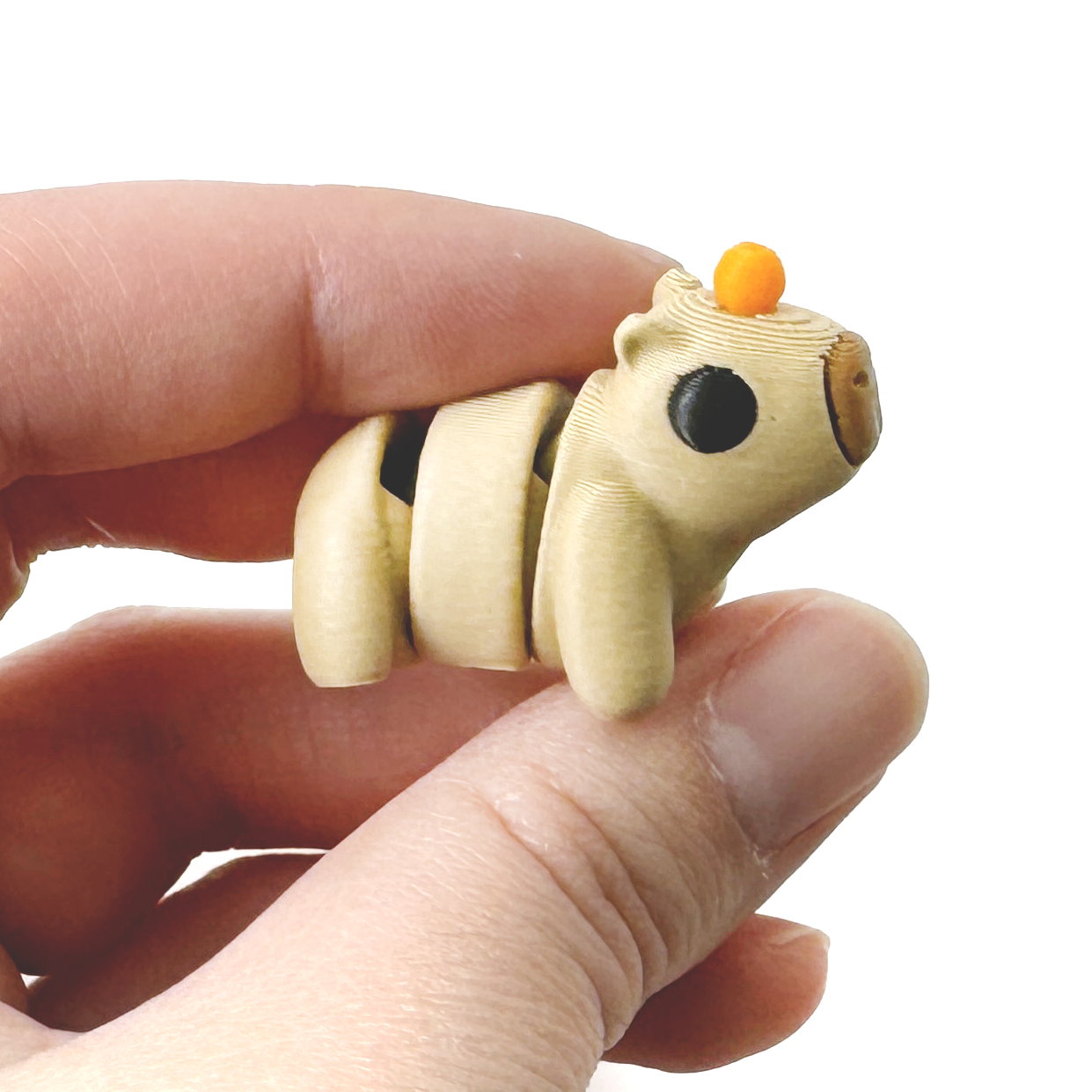 3D Printed Mini Capybara fidget with an orange on its head held in a hand
