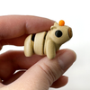 3D printed capybara mini fidget creature with an orange on its head being held