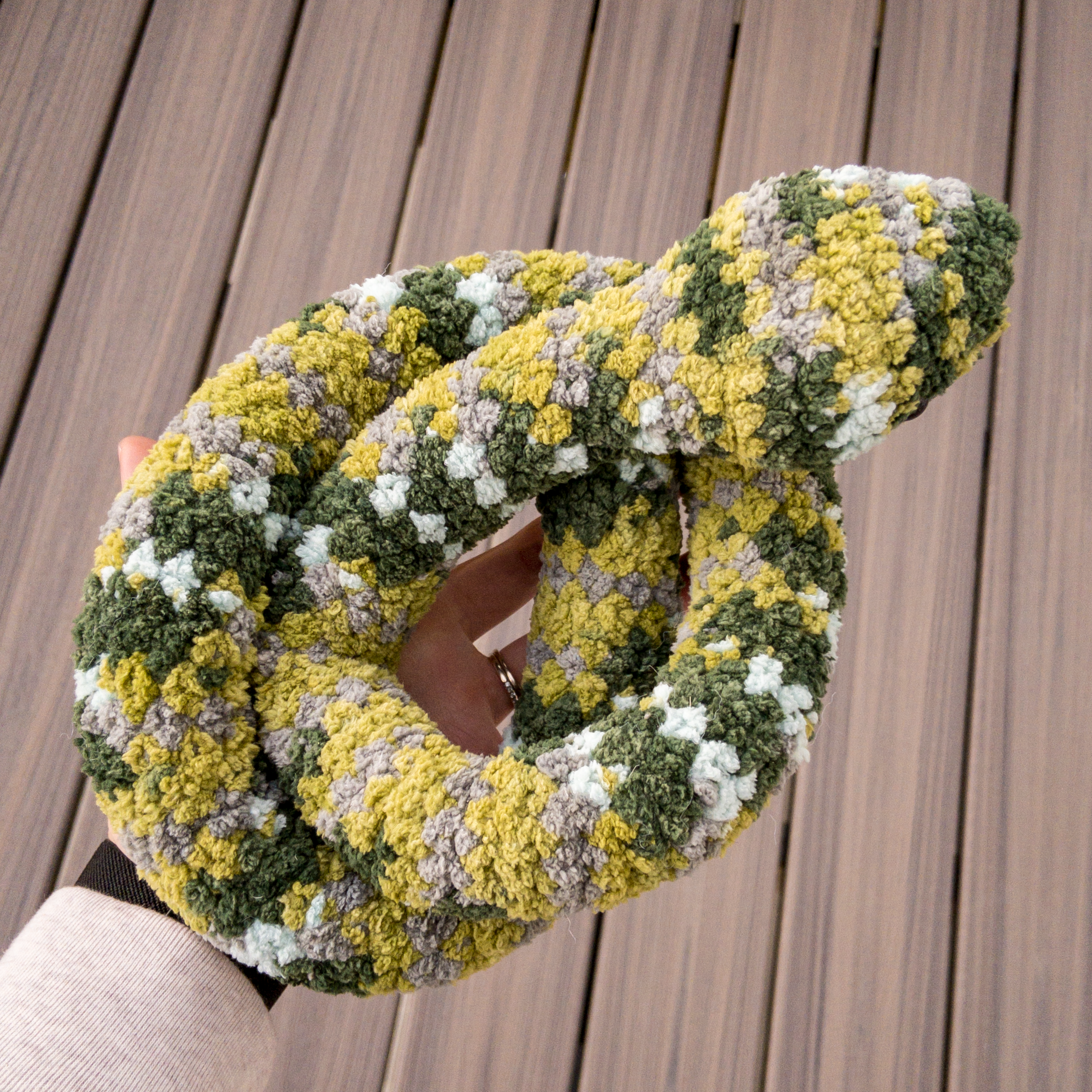 Crochet amigurumi snake curled in hand