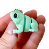 3D printed light green frog mini fidget creature being held