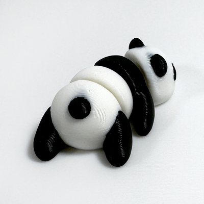 3D printed panda mini fidget creature laying on its belly facing backwards