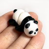 3D printed panda mini fidget creature laying on its belly being held